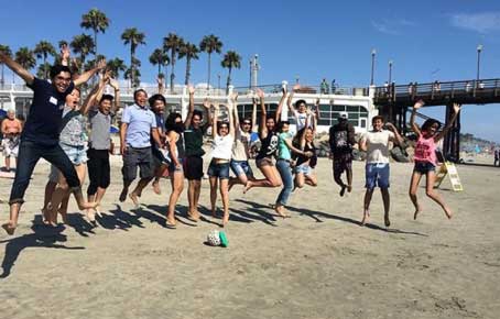 happy students jumping on beach