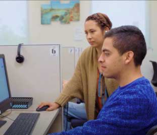 instructor helps student at computer