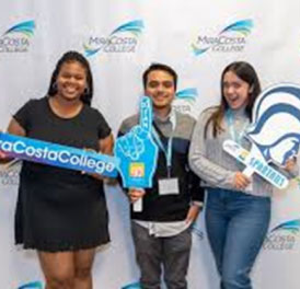 Happy students hold MiraCosta signs