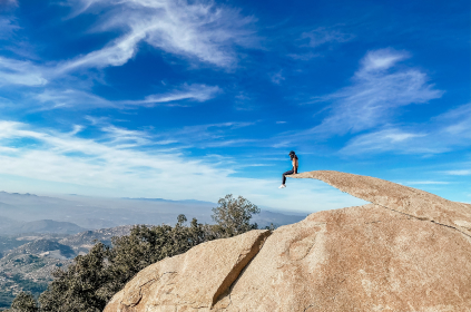 woman sitting on cliff overlook